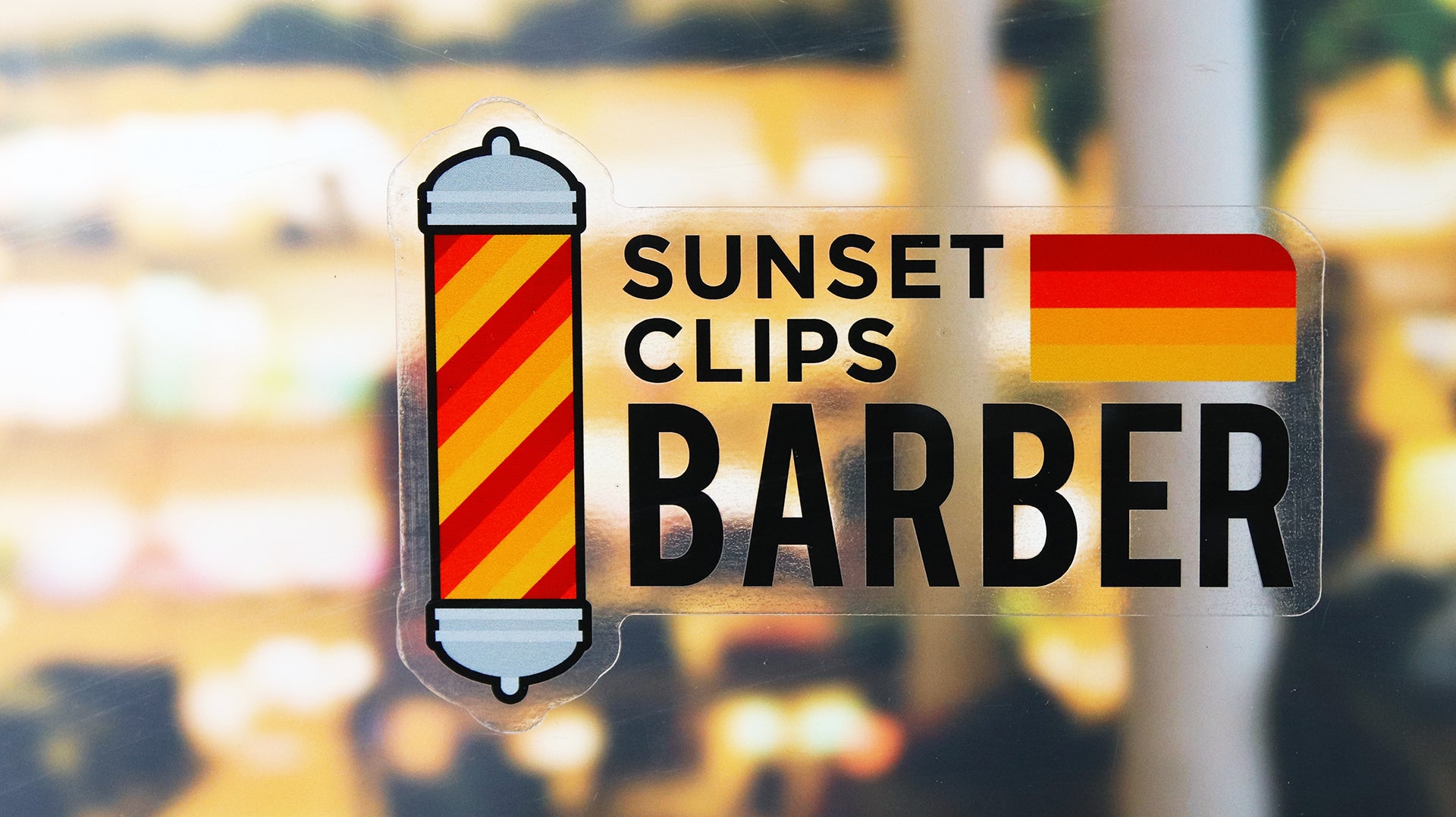 Eco-friendly front adhesive die-cut sticker with sunset clips barber logo applied to a window