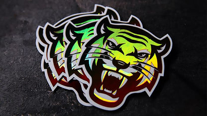 Stack of die cut holographic stickers with tiger design on a table