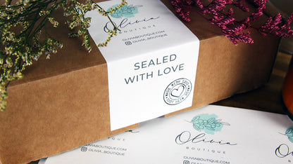 Biodegradable paper labels with logo and sealed with love design used as a packaging seal on a cardboard box