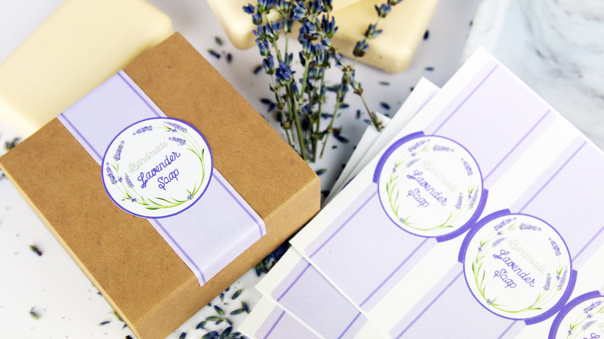Die-cut biodegradable paper packaging labels applied to a cardboard box filled with lavender soap