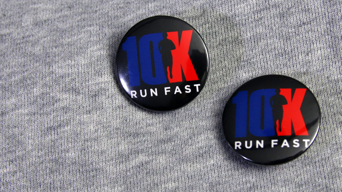 1.25" (32mm) 10k Runfest promotional button badges pinned to clothes