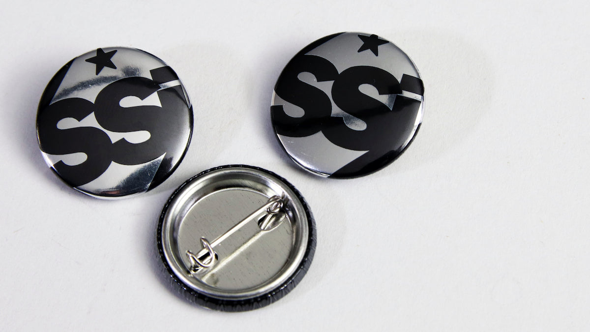 25mm (1-inch) mirror silver badge with SSi logo on it