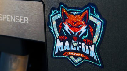 Die-cut glitter magnet with a MAXFOX logo stuck to a metal fridge