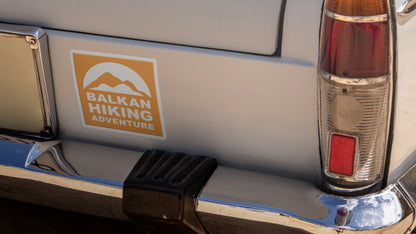 Square car magnet printed on white vinyl with hiking adventure logo applied to a silver car