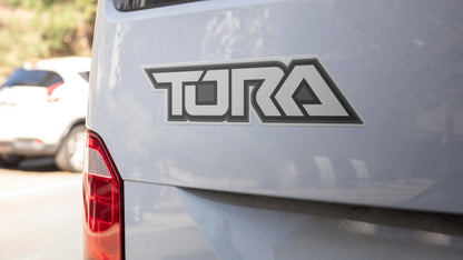 Die cut car magnet printed onto white vinyl with tora car logo applied to a car