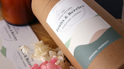Biodegradable paper compostable label with fruits and berries design applied to a cardboard tube next to additional sheet labels