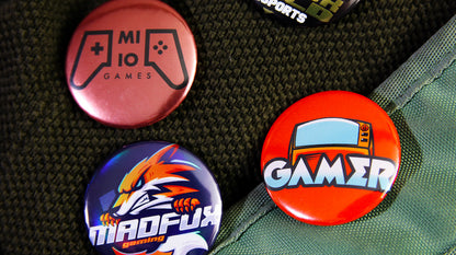 Custom full-colour logo button badges pinned to clothes and a green backpack