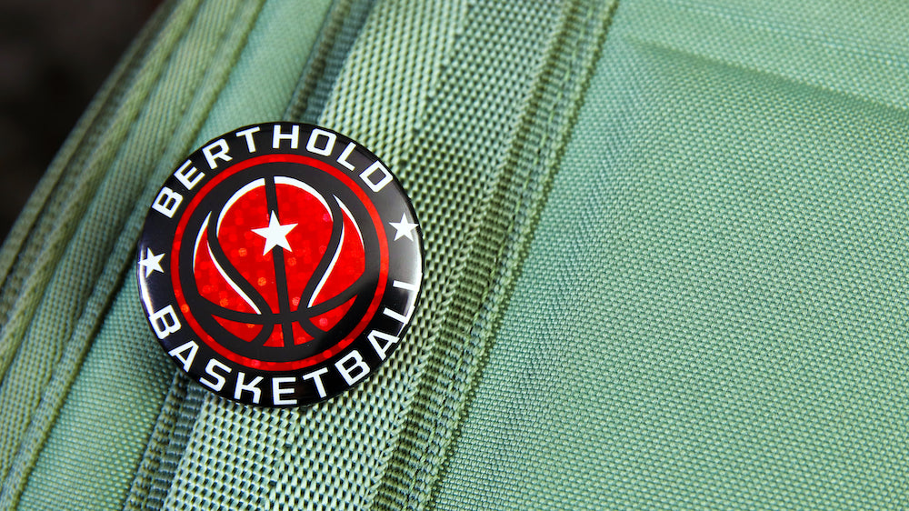 Glittery basketball logo 37mm, 1.5 inch button badge pinned to a bag