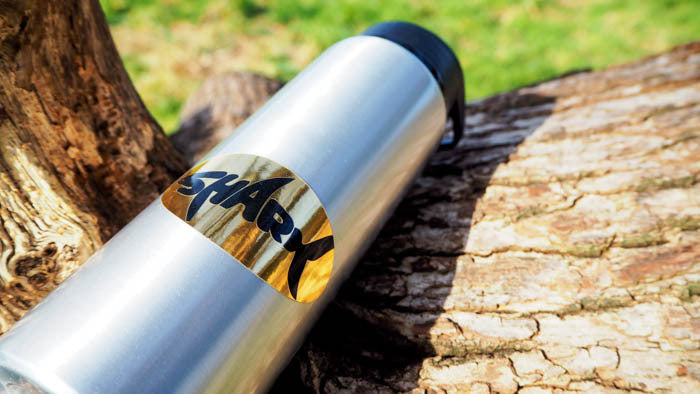 Mirror gold label oval shaped with shark logo applied to a water bottle