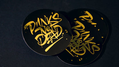 Punks not dead black and gold circle stickers in piles