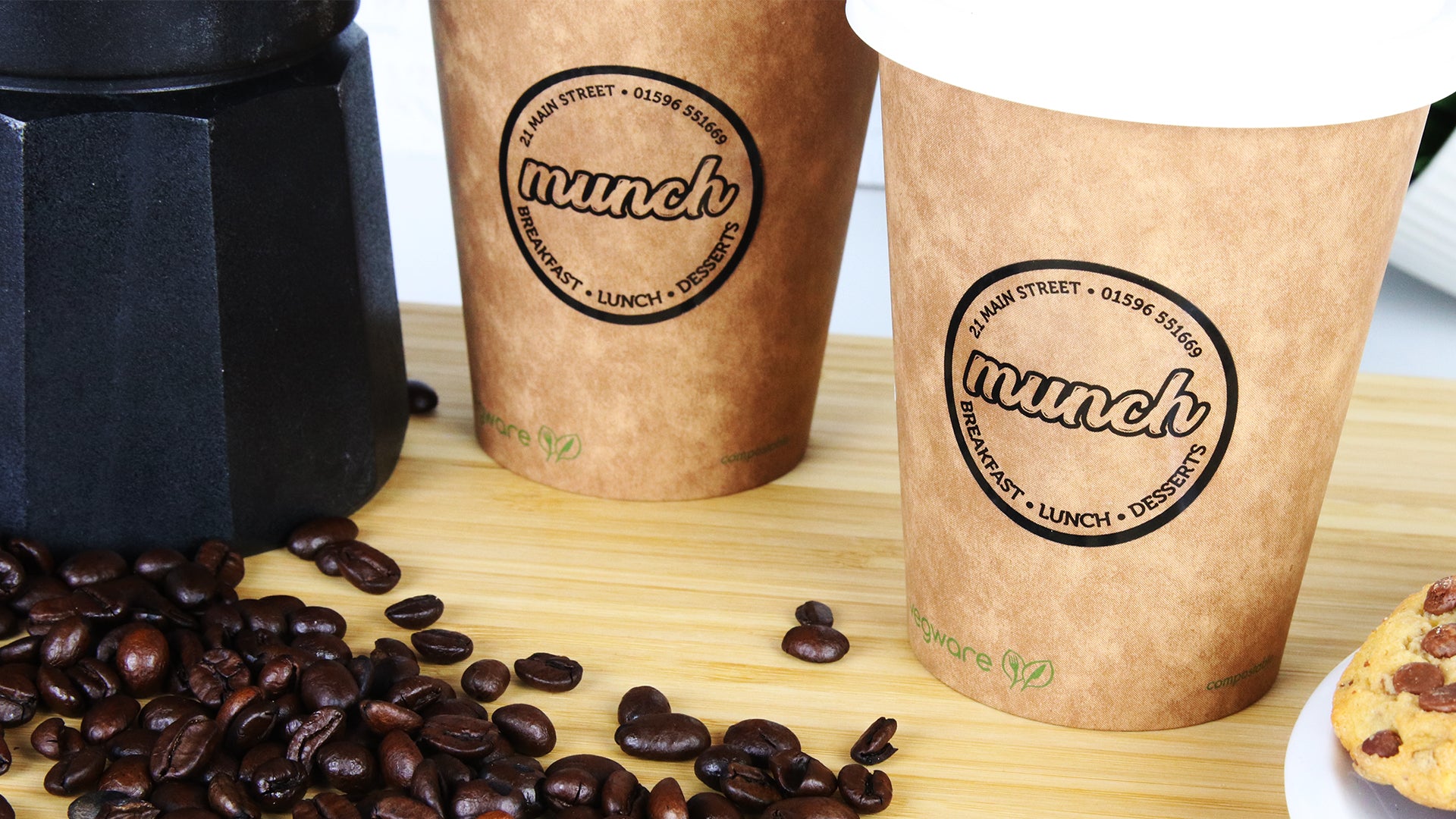 Round clear eco-friendly labels with Munch design applied to brown paper coffee cups
