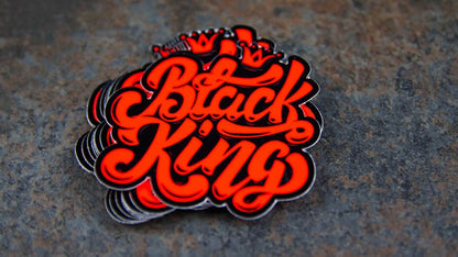 Stack of die-cut fluorescent red labels with black king design on a table