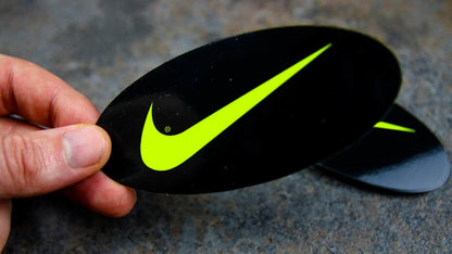 Stack of oval fluorescent yellow labels with Nike logo on a table