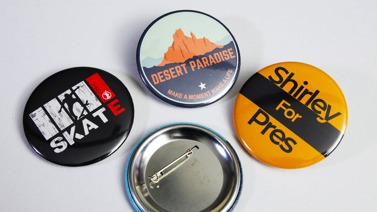 Various promotional designs printed on white 58mm button badges