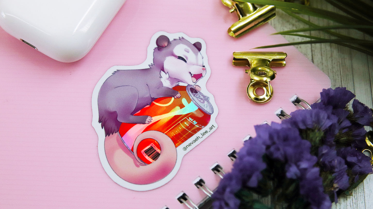 Holographic die cut sticker with cute rat holding a coca cola can applied to a pink notebook