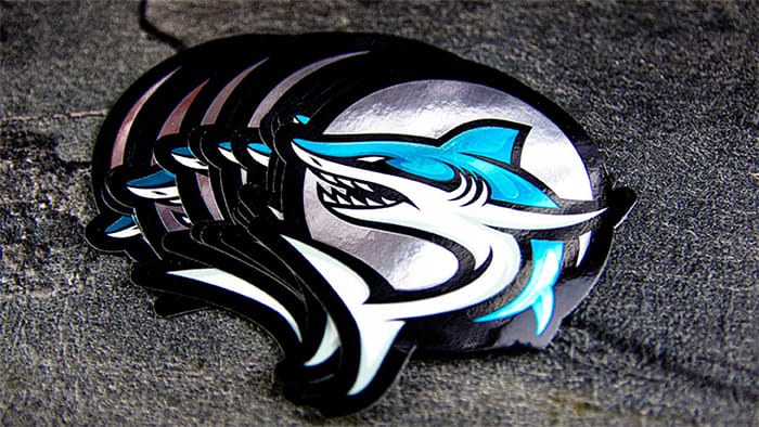 Stack die cut mirror silver sticker with shark design on a table