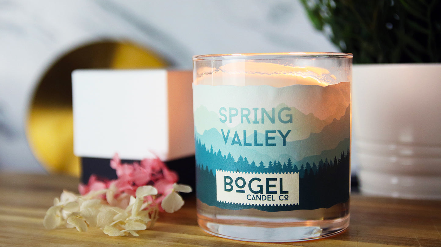 Biodegradable paper label with with spring valley design applied to a clear candle jar by the bogel company