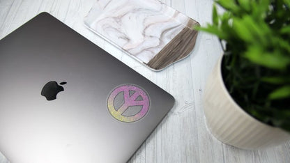 Circle eco-friendly clear stickers with a peace design applied to a silver laptop