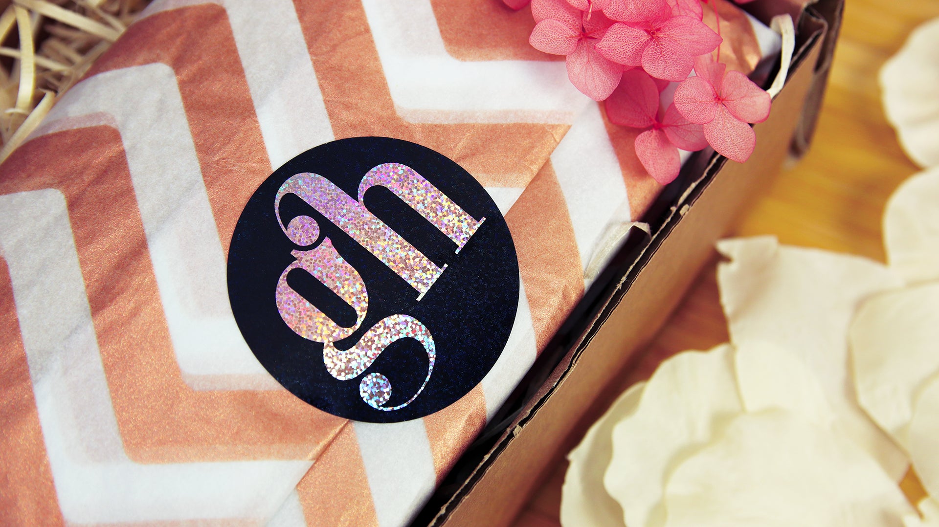 Circle eco-friendly glitter sticker with gh logo applied to secure wrapping paper