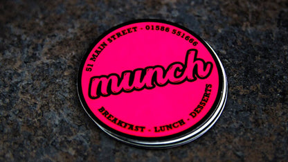 Circle fluorescent pink samples with munch design on a table