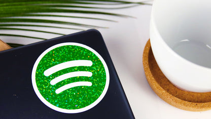 Circle glitter sticker with green Spotify logo applied to a laptop