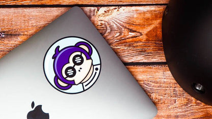 Circle white vinyl stickers with purple monkey design applied to a laptop