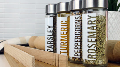 Clear labels applied to four spice jars filled with different spices