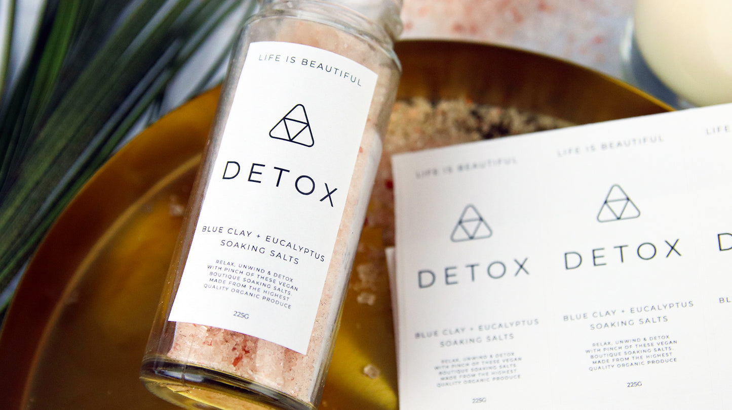 Rectangle biodegradable paper sheet labels with detox design applied to a clear glass jar filled with soaking salts