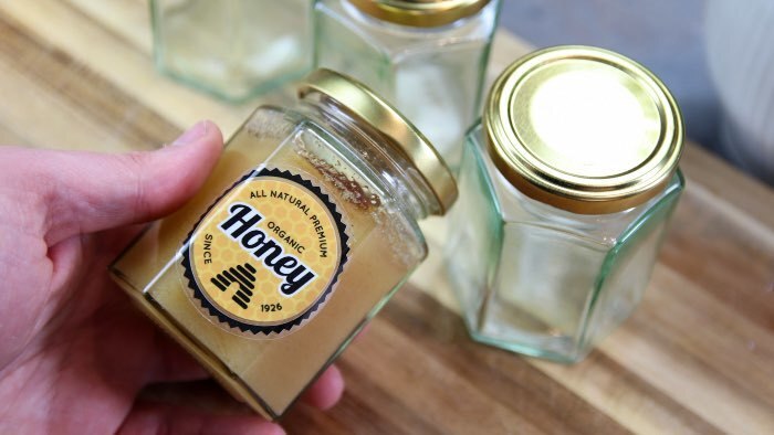 Die cut eco-friendly clear sticker applied to a honey jar
