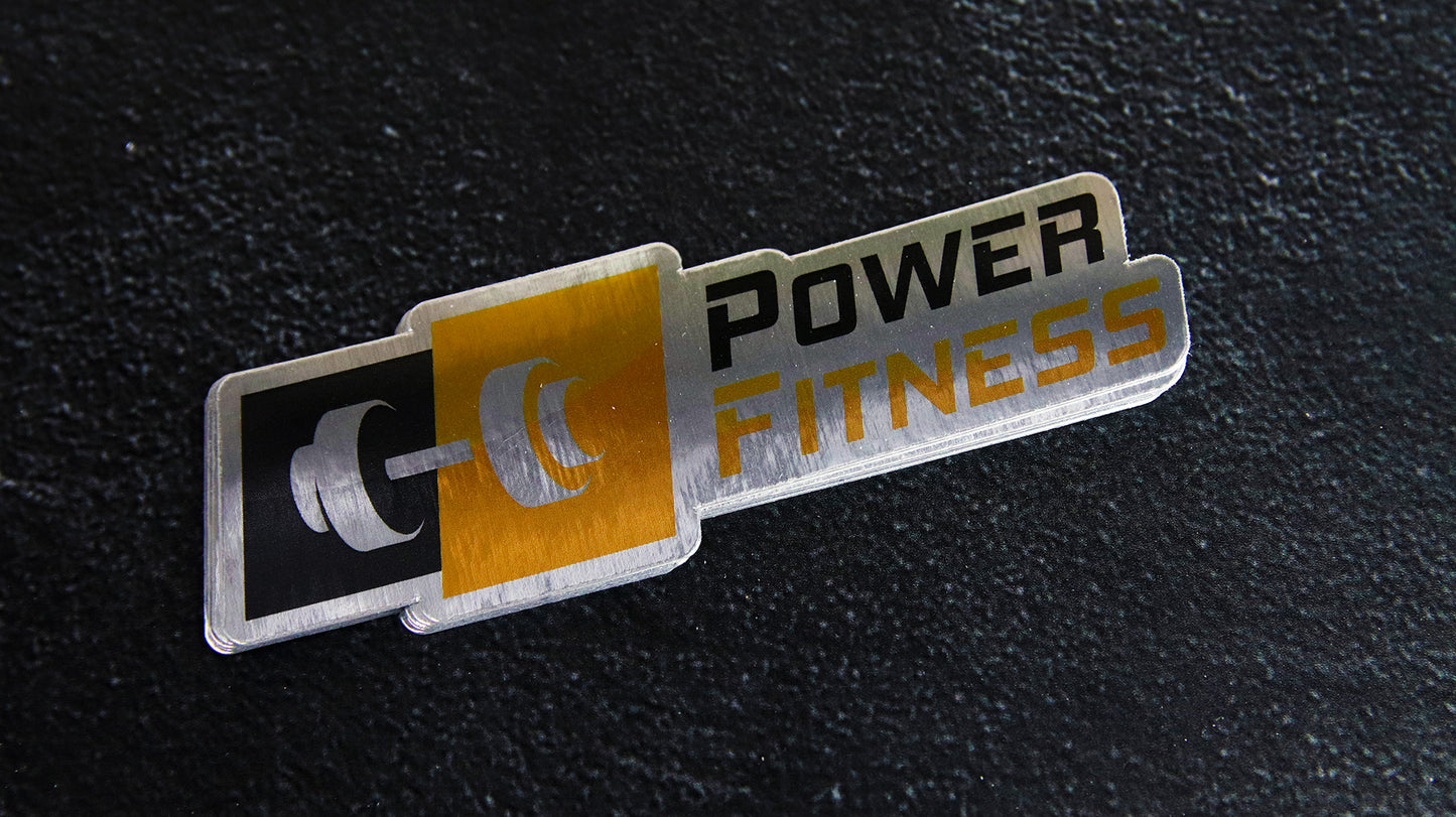 Die cut eco-friendly silver sticker with power fitness logo on a black table top
