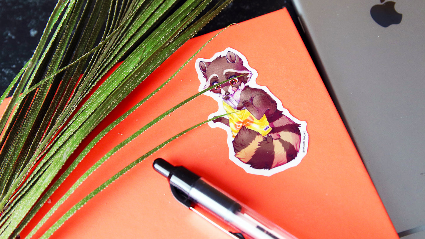 Die cut eco white sticker with cute racoon design applied to a notebook
