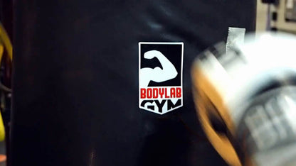 Die cut heavy duty sticker with gym logo applied to a punching bag