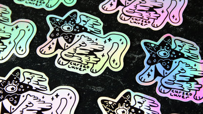 Die cut holographic stickers with cat art design on a black table