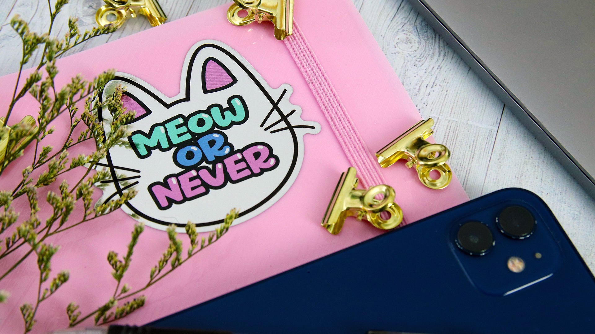 Die cut mirror silver sticker with meow or never design applied to a pink notebook