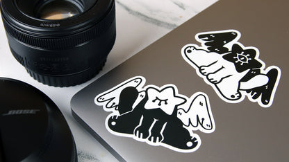 Die cut eco-friendly stickers with cat art design applied to a silver laptop