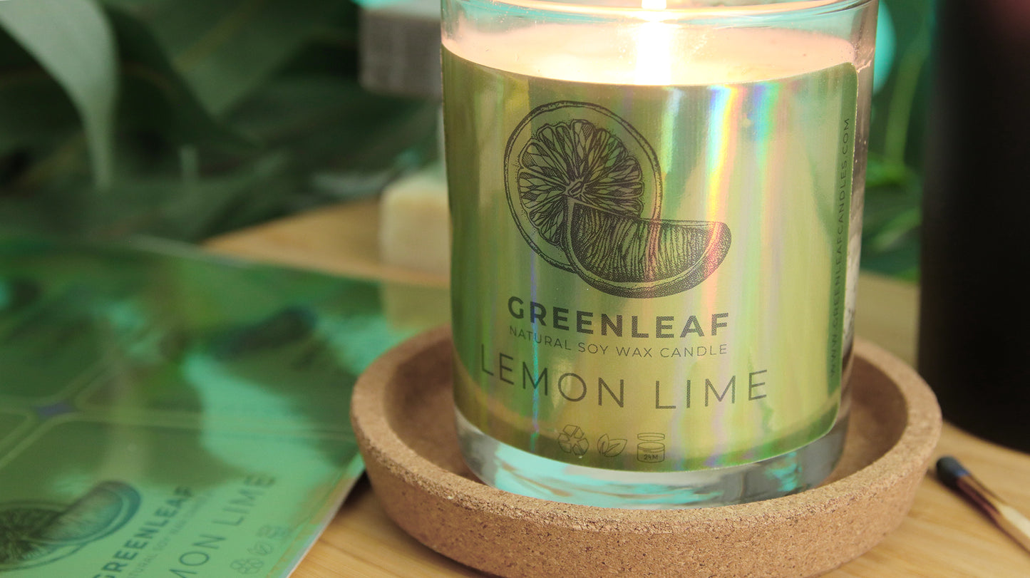 Eco-friendly holographic label with green leaf label applied to a candle next to sticker sheets