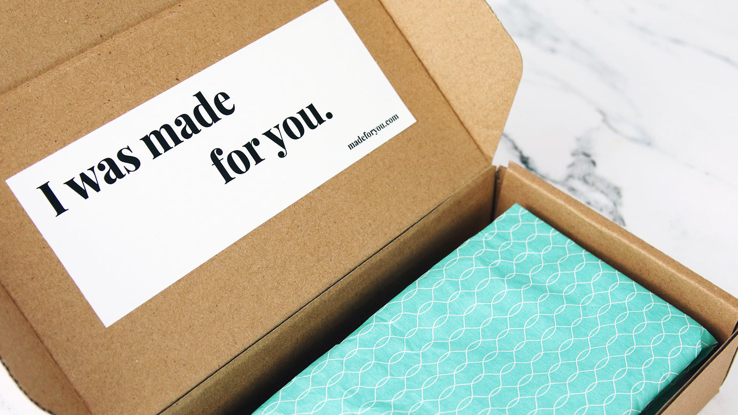 Eco friendly sticker with made for you design applied to the inside of an open cardboard box