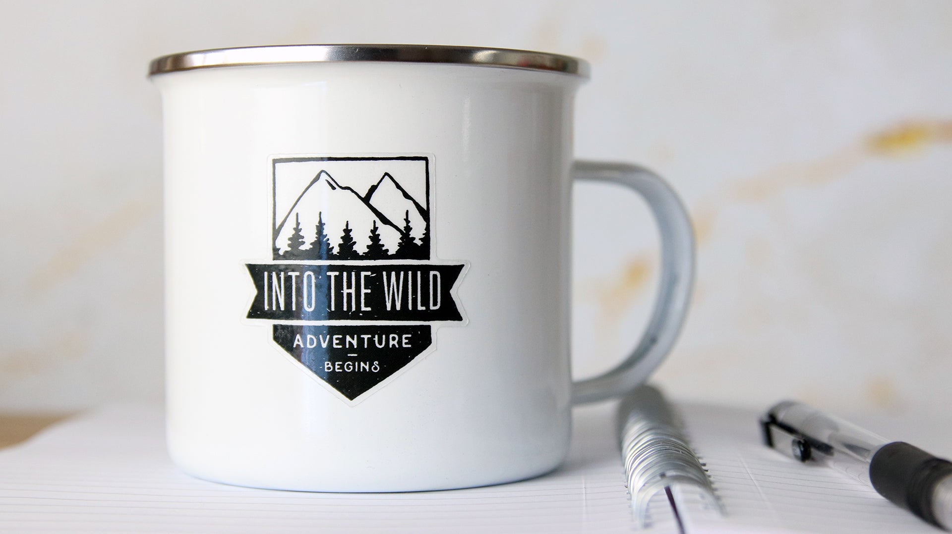 Die cut mug sticker with adventure design printed onto clear vinyl applied to a white mug