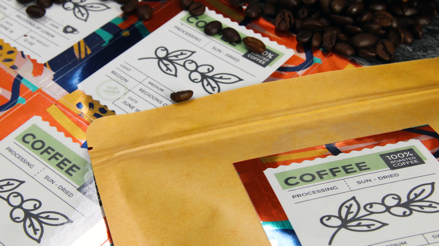 Rectangle eco-friendly silver label used as a coffee label on a brown bag next to sheets and coffee beans