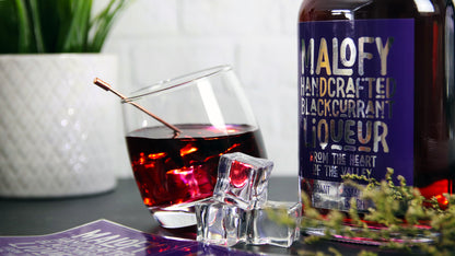 Rectangle mirror silver drinks label applied to a glass bottle containing blackcurrant liqueur