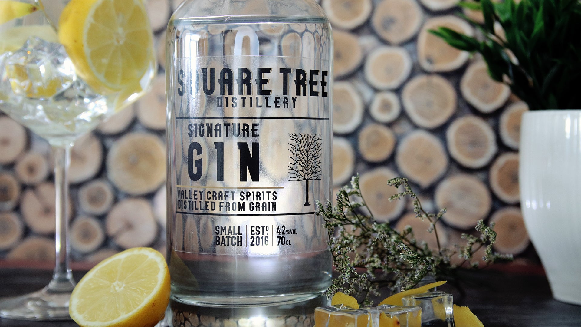 Rectangular clear eco friendly sticker applied to a clear gin bottle