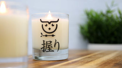 Rectangular eco-friendly clear stickers applied to a clear candle jar with a white candle