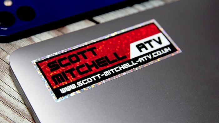 Rectangular glitter sticker with ATV logo applied to a silver laptop
