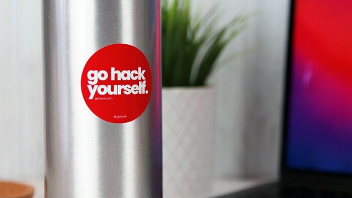 Round red eco-friendly sticker with go hack yourself design applied to a stainless steel water bottle