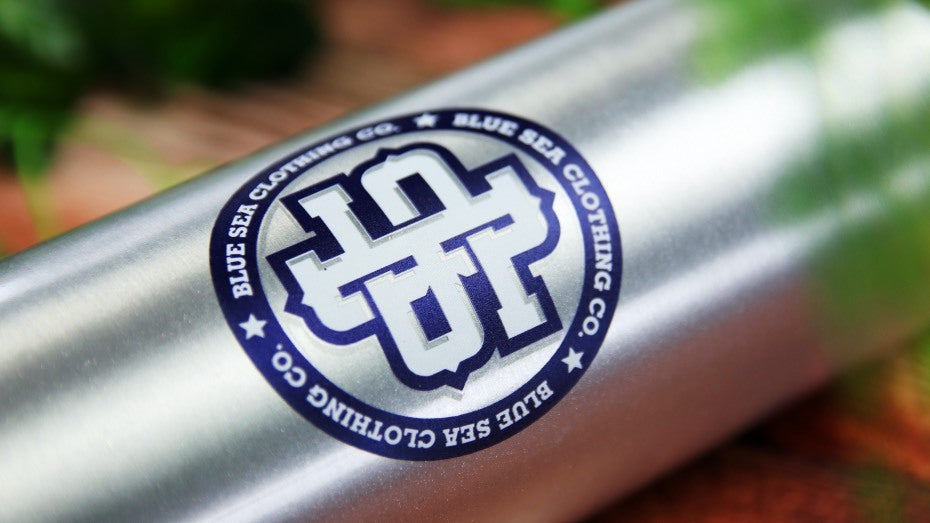 Round waterproof sticker with logo applied to a stainless steel water bottle
