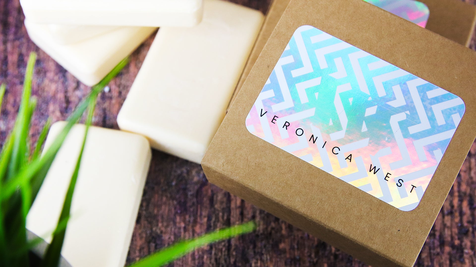 Rounded corner holographic company label with victoria west logo on cardboard soap boxes