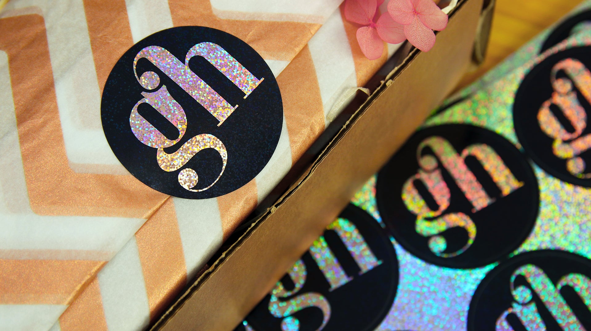 Sheet of circle eco-friendly glitter labels with gh logo and one applied to secure wrapping paper