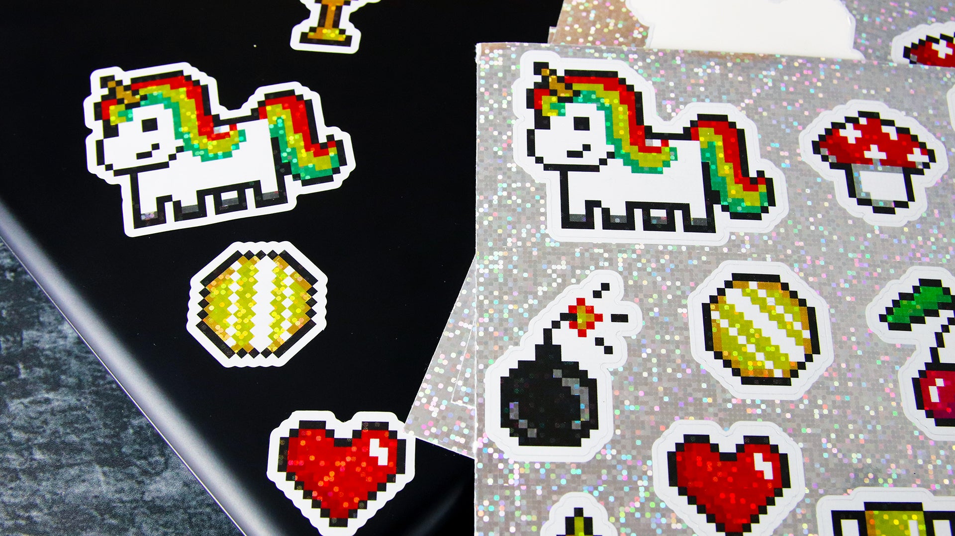 Sheet with glitter labels with different cute designs applied to a black laptop