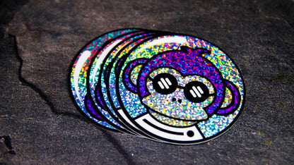 Stack of circle glitter stickers with purple monkey design on a table