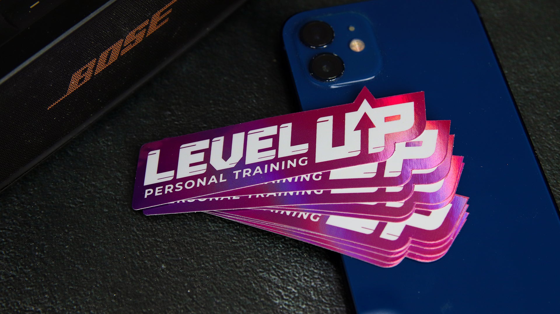 Stack of eco-friendly holographic die cut stickers with level up logo